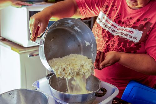 Agricultora drenando coalhada para preparo de queijo artesanal em sua moradia no Assentamento Eli Vive - MST M