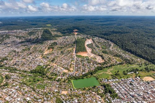 Vista de drone do contraste da floresta do Jardim Botânico Adolpho Ducke do INPA e moradias da cidade