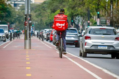 Ciclista entregador de comida por aplicativo na ciclovia da Avenida Paulista