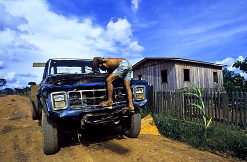 Homem consertando carro velho no distrito de Extrema de Rondônia