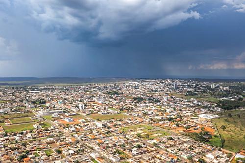 Vista de drone da cidade com chuva ao fundo - 