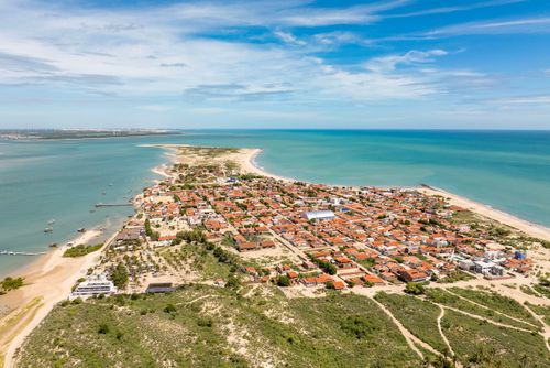 Vista de drone da cidade e praia de galinhos - mar de fora à esquerda e de dentro à direita  - Polo Costa Br