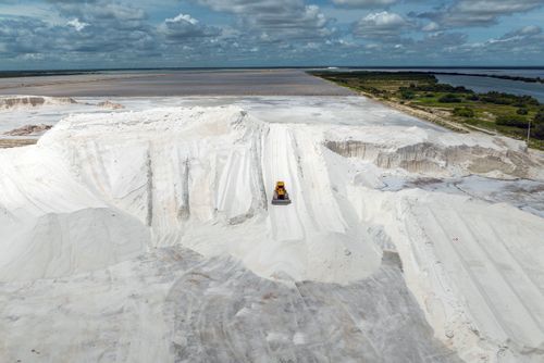 Vista de drone de trator de esteira movimentando sal de indústria salineira - Polo Costa Branca