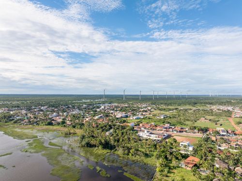 Vista de drone da Lagoa do Cardeiro ao lado da cidade e ao fundo Complexo Eólico União dos Ventos