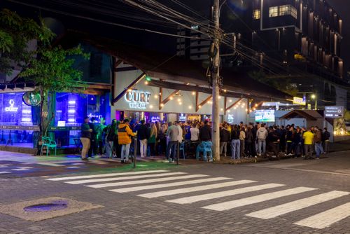  Cena noturna com concentração de clientes em um dos bares e restaurantes da Rua Curt Hering - centro