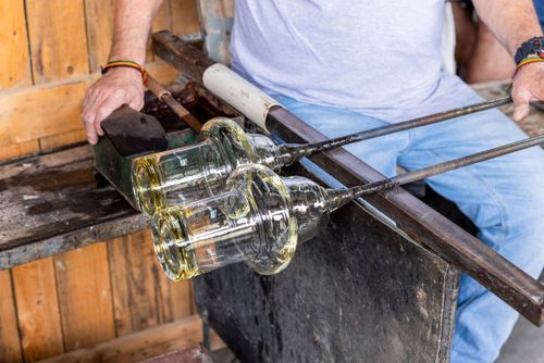 Artista vidreiro modelando peça de cristal em alta temperatura - fábrica de cristal