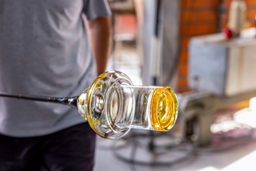 Artista vidreiro modelando peça de cristal em alta temperatura - fábrica de cristal