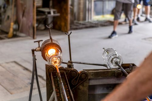 Artista vidreiro modelando peça de cristal em alta temperatura - fábrica de cristal