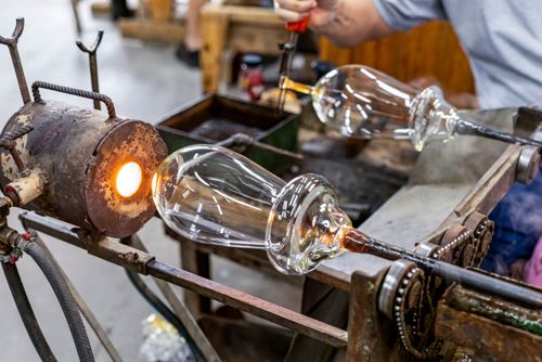 Artista vidreiro modelando peça de cristal em alta temperatura - fábrica de cristal