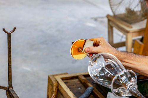 Artista vidreiro modelando peça de cristal em alta temperatura - fábrica de cristal
