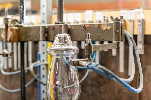 Artesão usa maçarico para corte térmico da borda do copo de cristal - fábrica de cristal