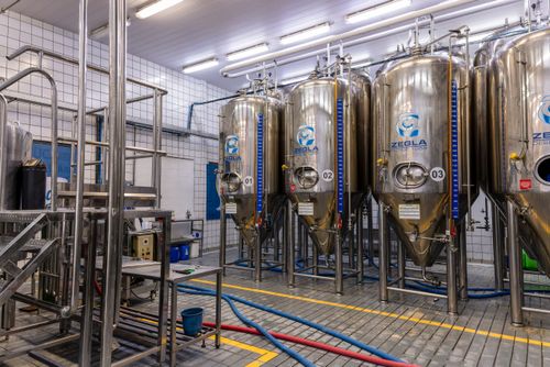 Vista interna de cervejaria artesanal - tanques para fermentação em inox