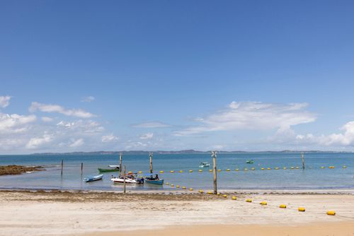 Barcos ancorados para transporte de turistas e boias de contenção e sinalização para banhistas - Praia da 
