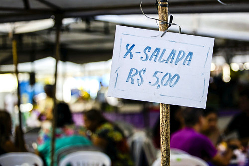 Placa de venda de lanche X-salada com preço em feira no centro na Avenida Eduardo Ribeiro