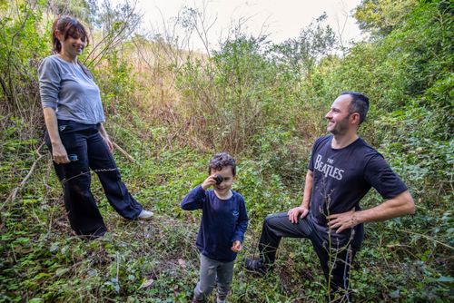 Família fazendo trilha em meio à vegetação de capoeira e mata atlântica