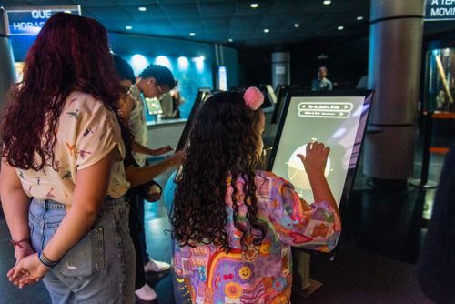 Menina interagindo com painel digital no Museu do Universo no Planetario do Rio