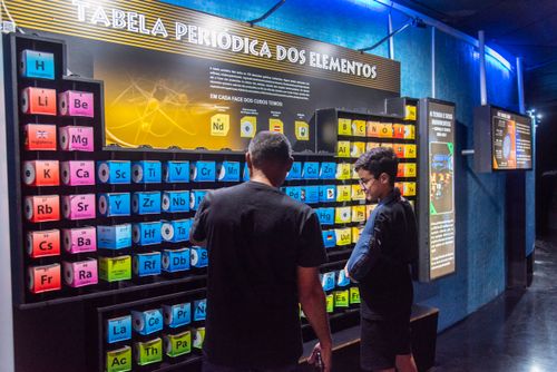 Pai e filho interagem com tabela periódica dos elementos no Museu do Universo no Planetário do Rio