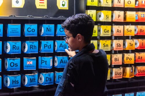 Menino interagindo com tabela periódica dos elementos no Museu do Universo no Planetário do Rio