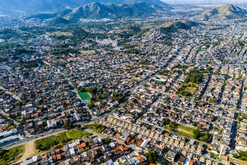 Vista de drone de moradias do bairro Santíssimo e ao fundo Parque Natural Municipal da Serra do Mendanha