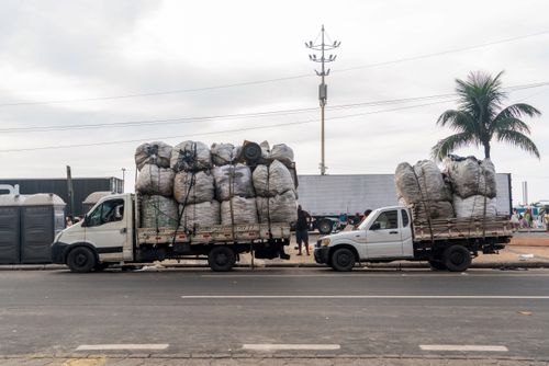 Caminhão recolhendo sacos de latinha de alumínio para reciclagem na Praia de Copacabana