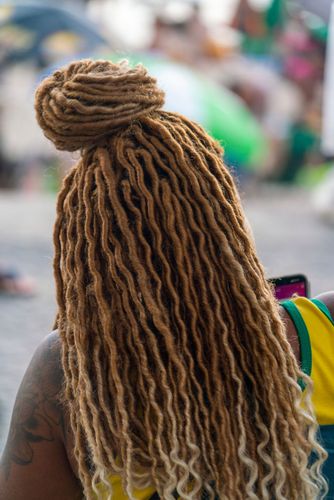 Mulher negra com tranças no cabelo em estilo dread na Praia de Ipanema
