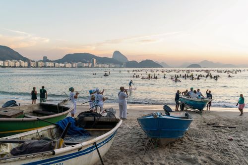 Grupo de pessoas fazendo homenagem para Iemanjá ao nascer do sol na colônia de pescadores Z-13 na Praia de C