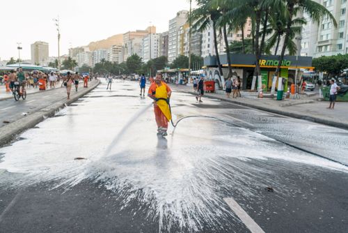 Gari fazendo a limpeza na Avenida Atlântida após a passagem de bloco de carnaval de rua
