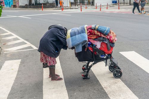 Mulher sem teto carregando seus objetos na avenida Atlântica