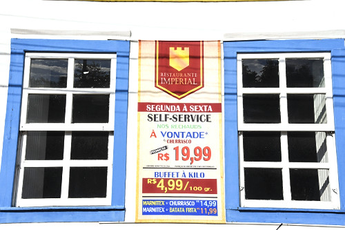 Anúncio de buffet à kilo e preços na fachada de restaurante - 