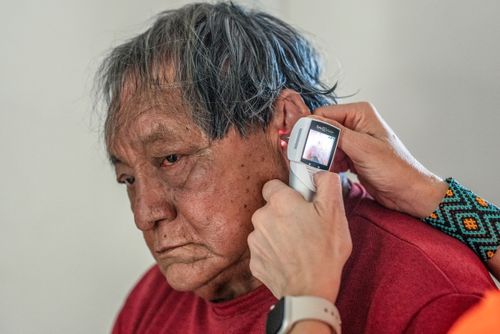 Uso de otoscópio durante exame médico em indígena da etnia Kuikuro - Aldeia Ipatsé - Parque Indígena do X