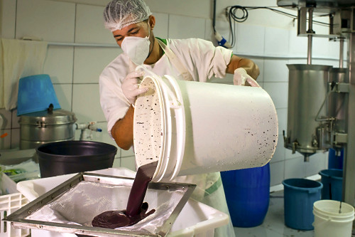 Trabalhador peneirando polpa de açaí