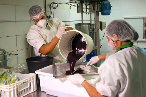 Trabalhador peneirando polpa de açaí