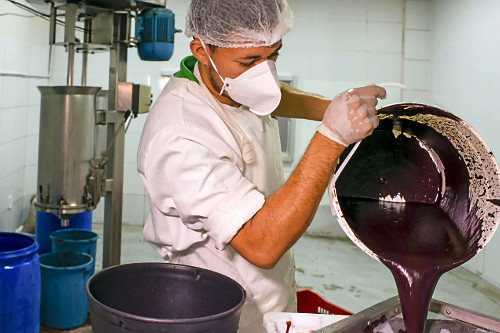 Trabalhador peneirando polpa de açaí