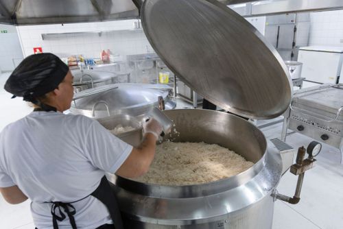 Arroz branco preparado em grande quantidade em caldeirão industrial no restaurante de preço popular 