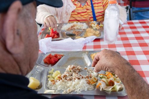 Pessoas se alimentando no restaurante de preço popular com arroz feijão strogonoff de frango salada de repol