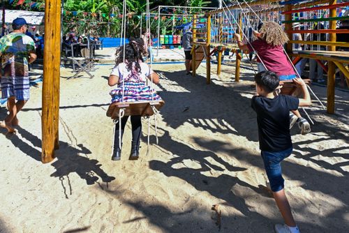 Crianças brincando em balanço durante festa junina na Escola Municipal Agostinho Ferreira Mattos na Praia da