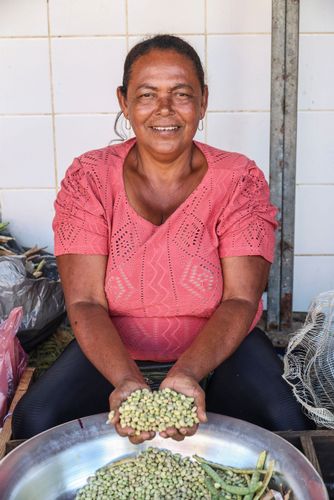 Feirante exibe feijão verde debulhado à venda em sua barraca na feira livre no entorno do CEASA Edmundo Flor