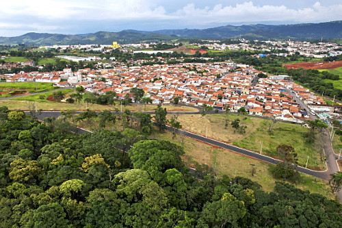 Vista de drone de mata nativa na zona rural e moradias na periferia da cidade