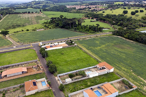 Vista de drone de loteamento entre plantação de soja - crescimento da cidade sobre área rural